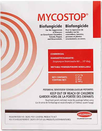 Gros plan de l'emballage du biofongicide Mycostop isolé sur fond blanc.