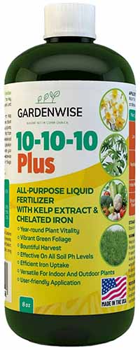 Un gros plan d'une bouteille d'engrais Gardenwise 10-10-10 isolée sur un fond blanc.