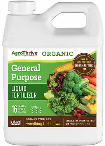 Une image verticale rapprochée d'une bouteille en plastique d'engrais liquide à usage général agrothrive isolé sur fond blanc.