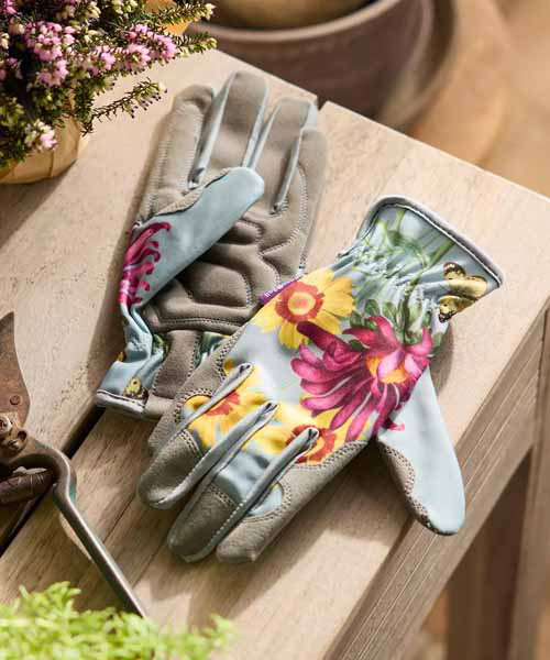 A bas sur la vue sur les gants de jardinage avec un imprimé floral de diverses fleurs Asteraceae.