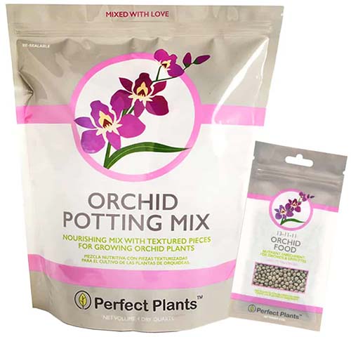 Un gros plan de l'emballage du terreau d'empotage pour orchidées entièrement naturel Perfect Plants, avec un petit paquet d'engrais à droite du cadre.