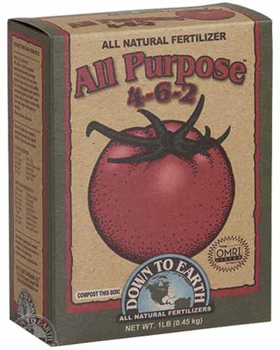 Un gros plan de l'emballage de l'engrais tout usage Down to Earth isolé sur un fond blanc.