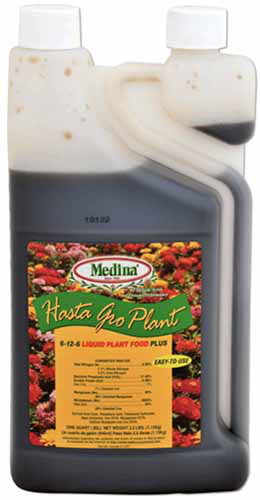 Un gros plan de l'emballage de l'engrais Hasta Gro Plant isolé sur un fond blanc.